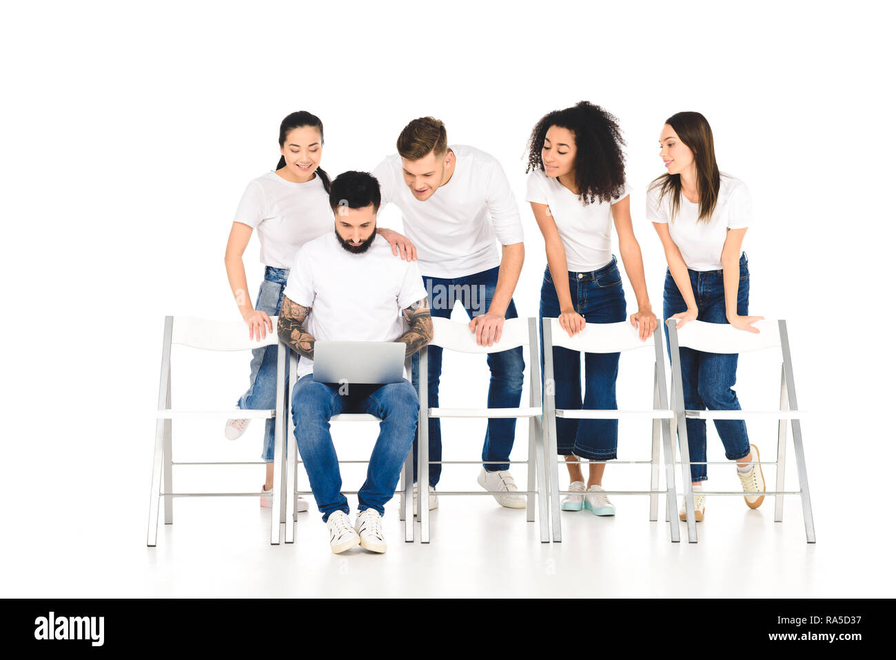 bearded man using laptop while multicultural group of young people standing behind and looking at screen isolated on white Stock Photo