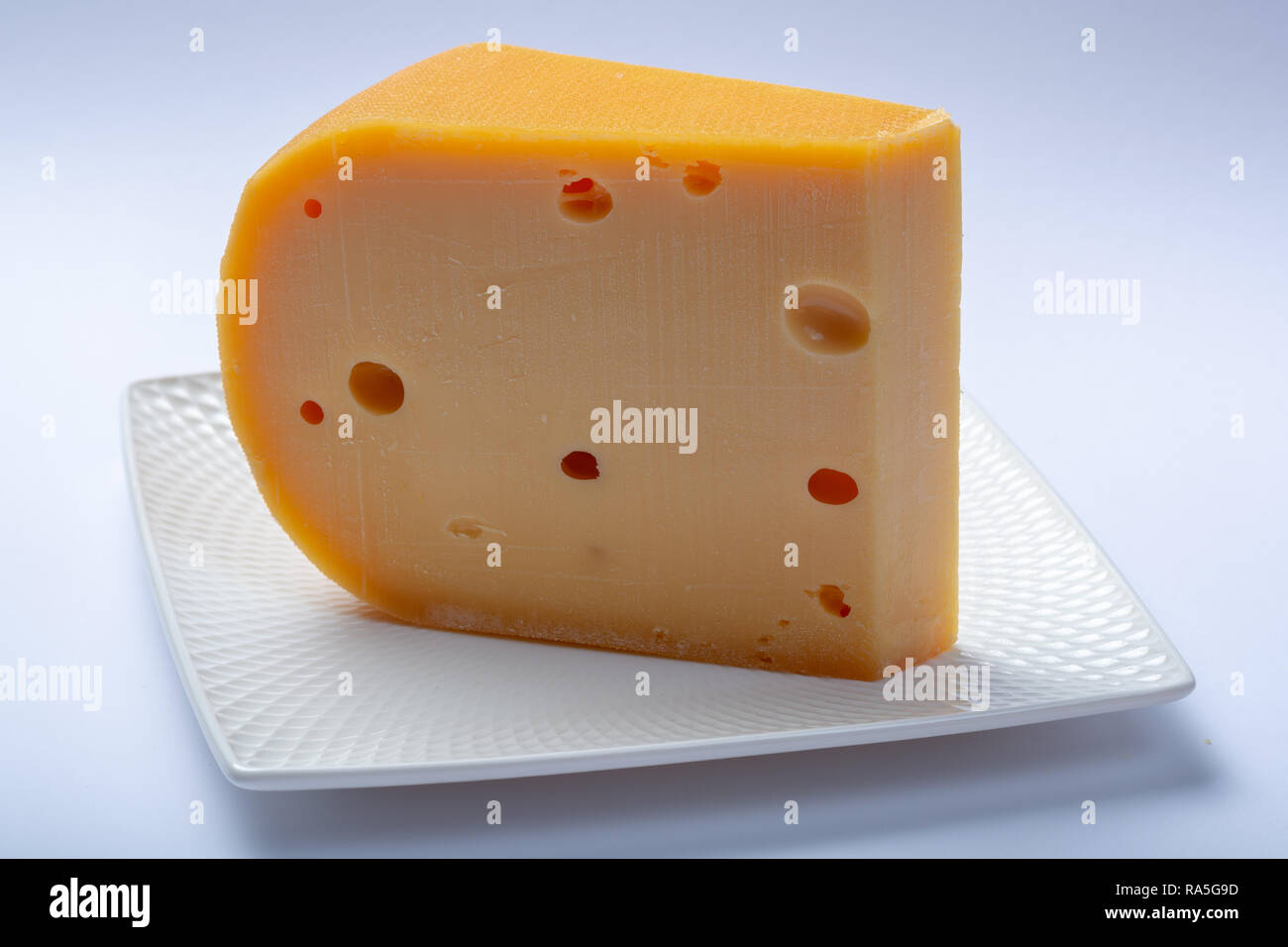 One piece of traditional Dutch old hard cheese made from cow milk close ...