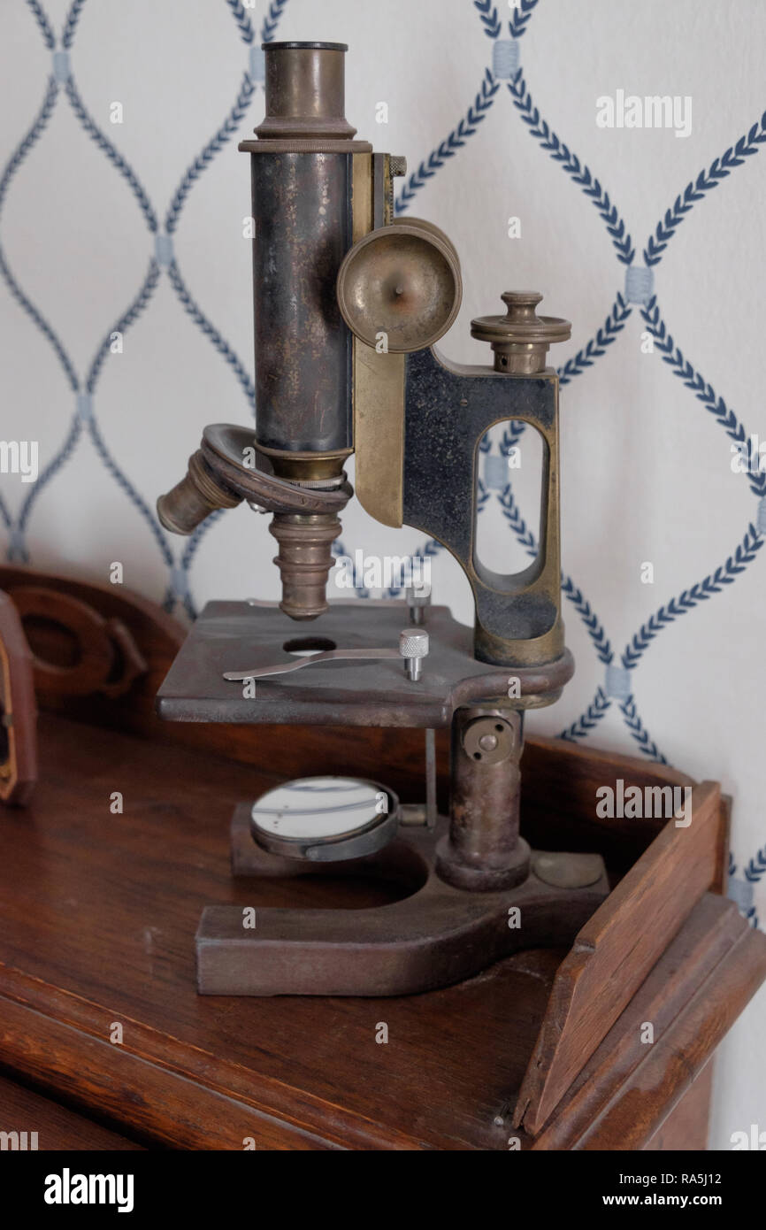 Antique microscope & vintage wall paper. Interior of old Texan home, Chestnut Square  Historic Village, McKinney Texas. Stock Photo