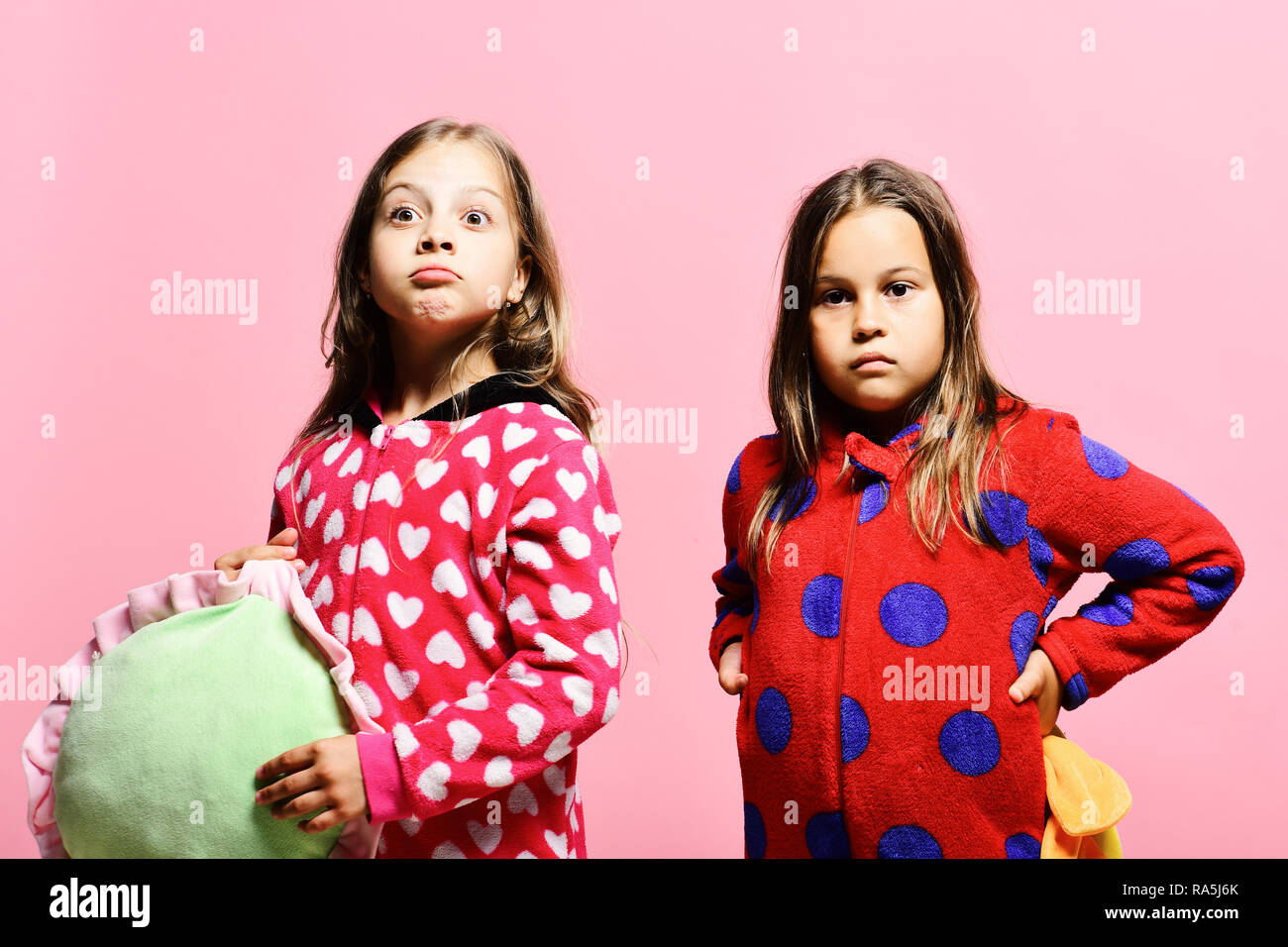 Kids With Surprised Faces Hold Green And Yellow Pillows Girls