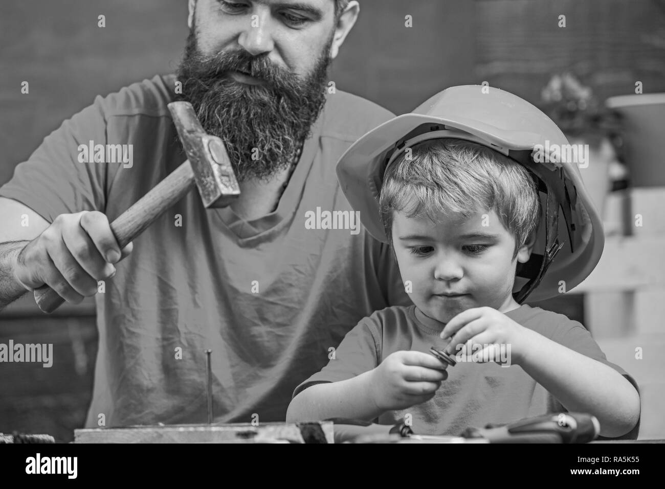 Masculine duties concept. Father, parent with beard teaching little son