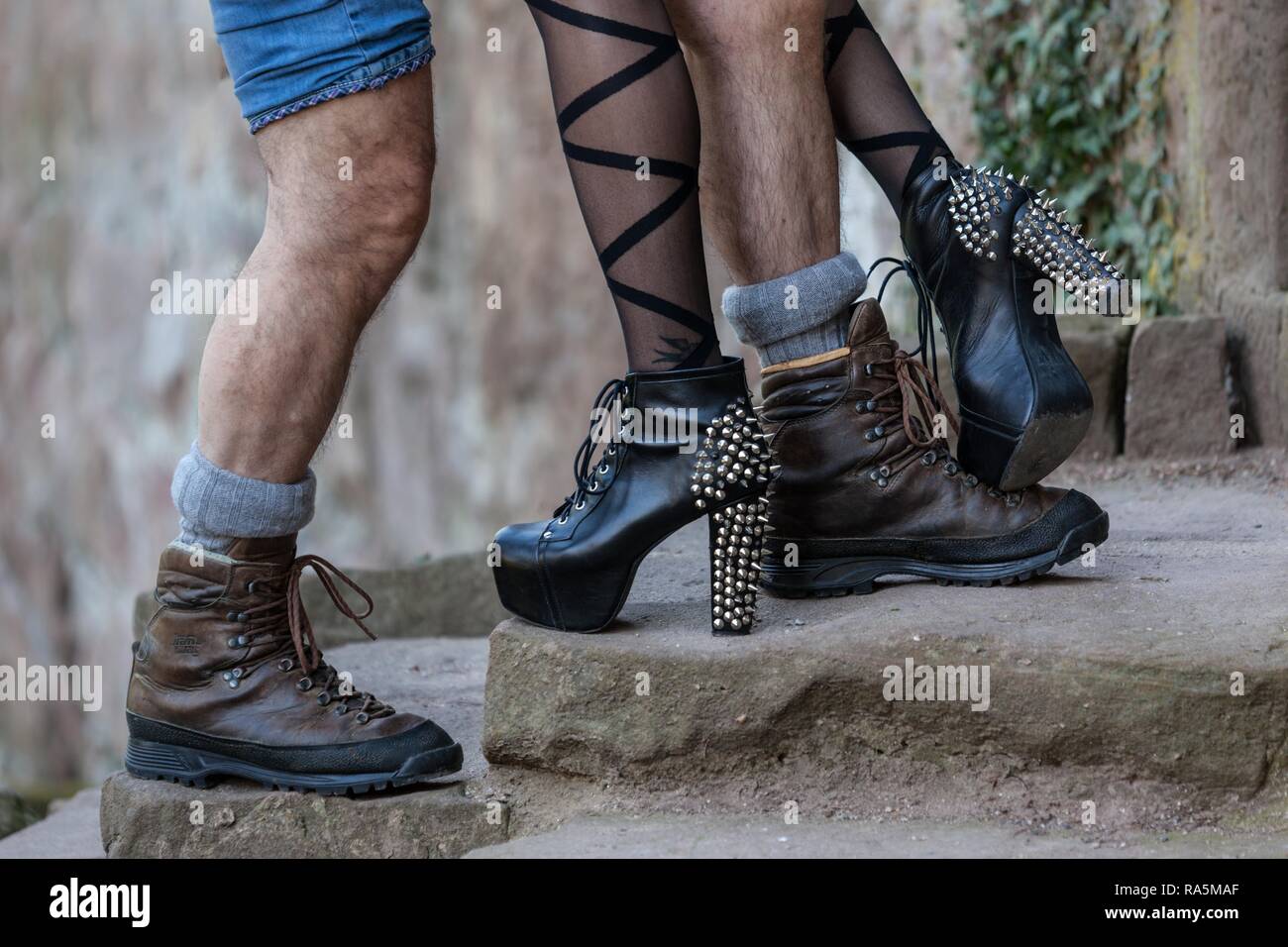 Legs of a man with mountain boots and a woman with high heels, Germany Stock Photo