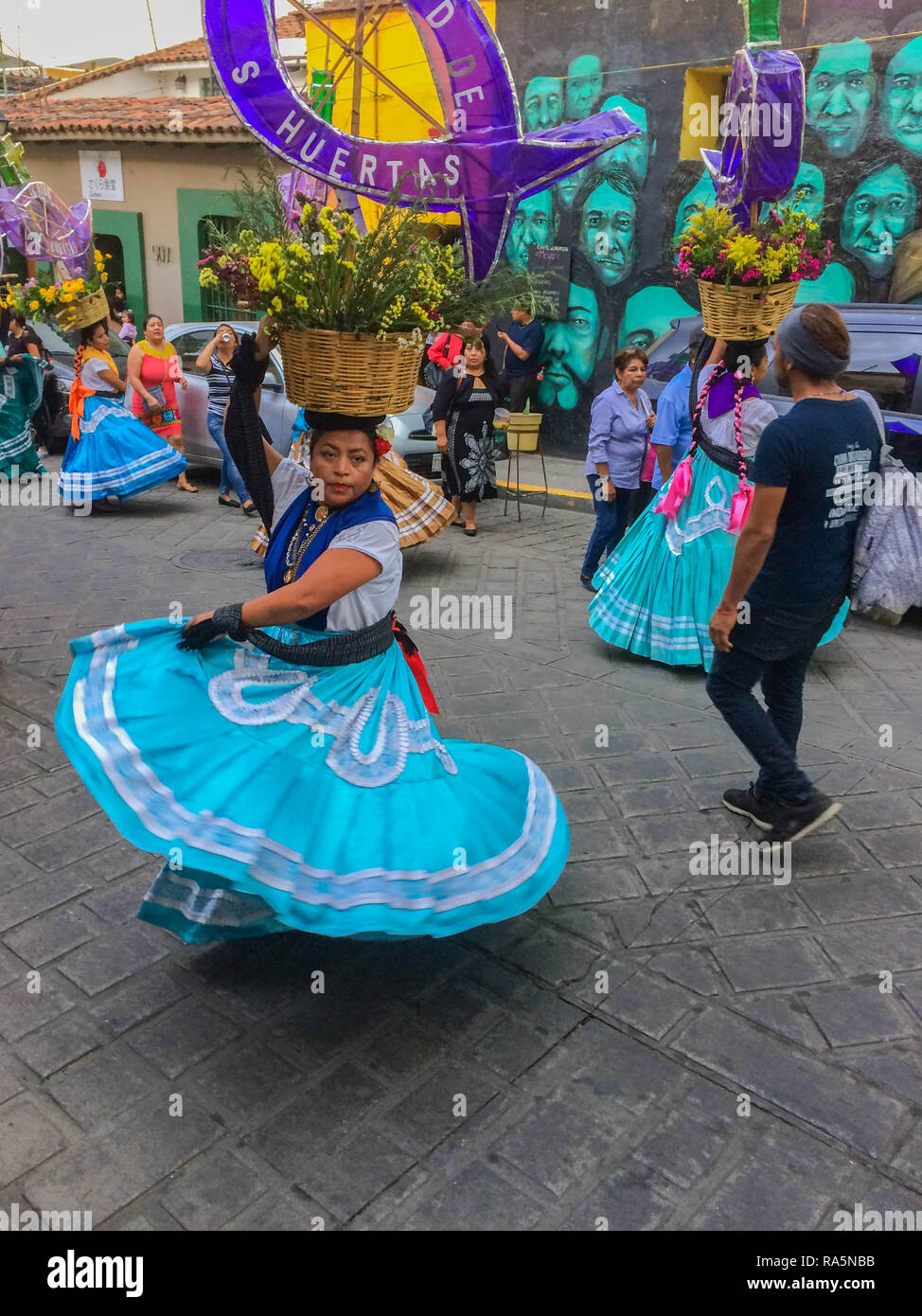 Dancers in beautifully colored traditional clothing with baskets on