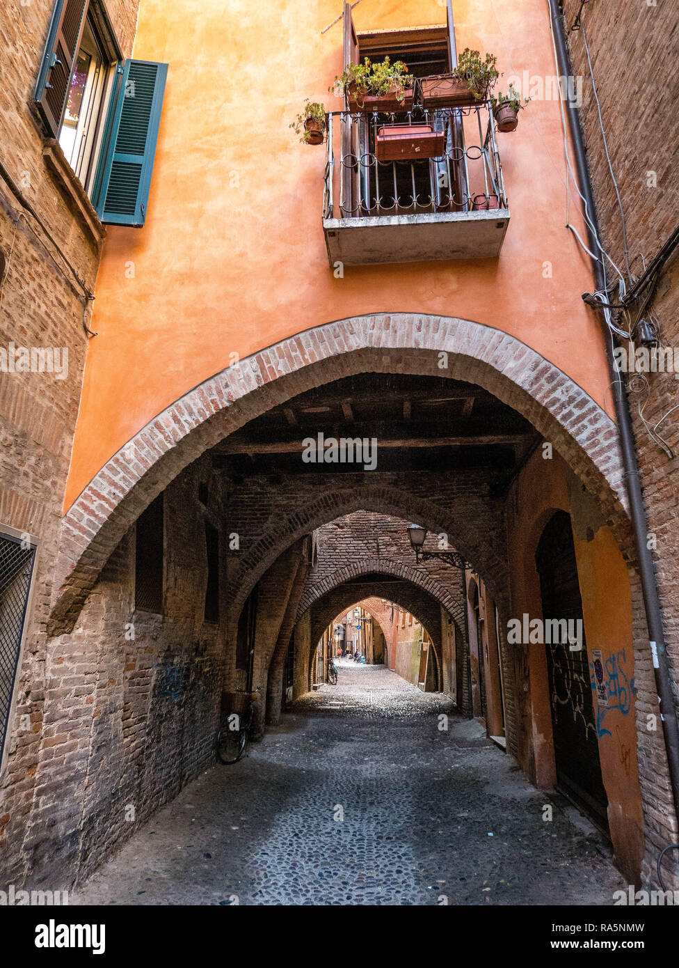 Narrow streets and arches in the medieval town of Ferrara, Italy Stock Photo