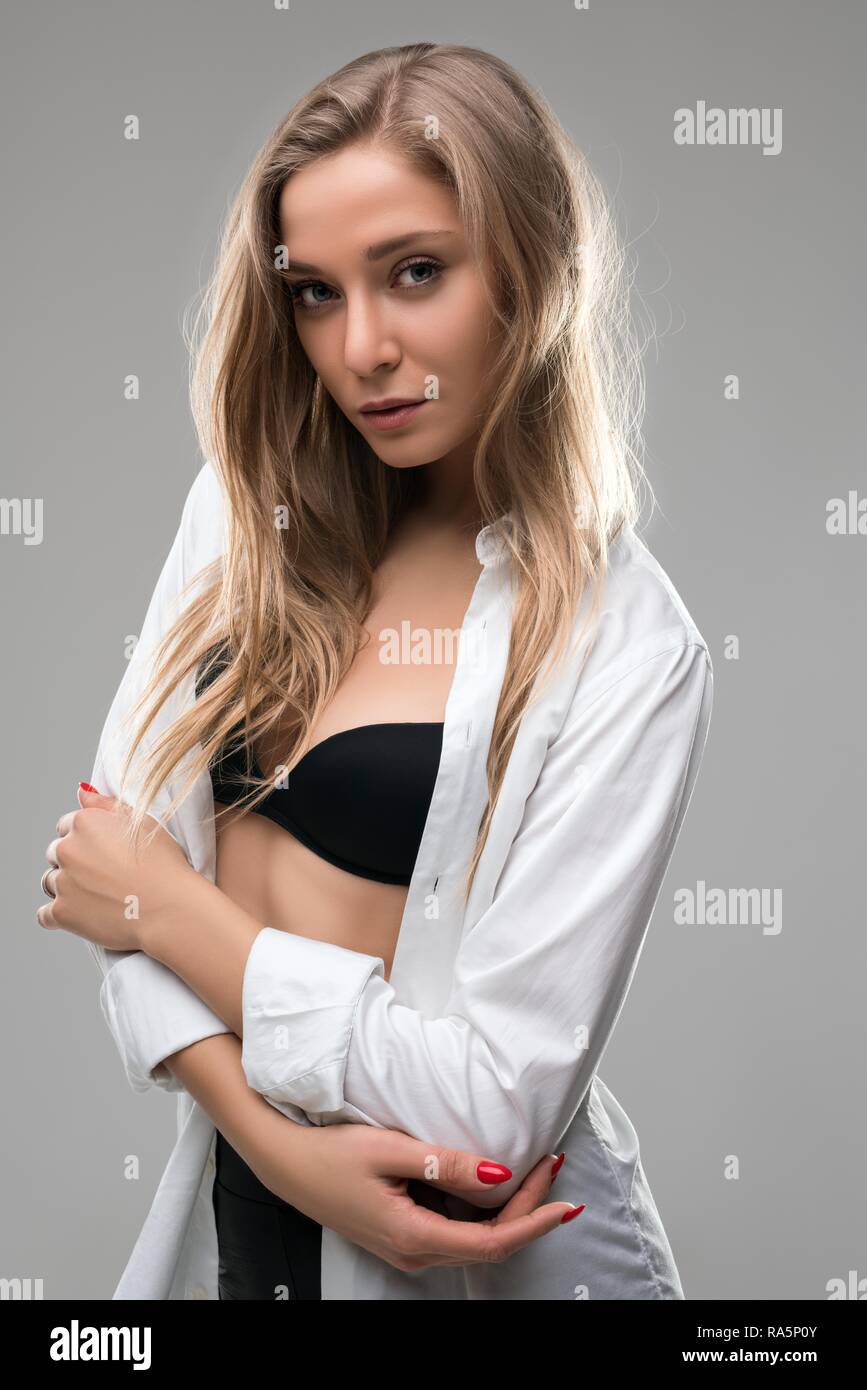 Blonde in black bra and white unbuttoned shirt Stock Photo - Alamy
