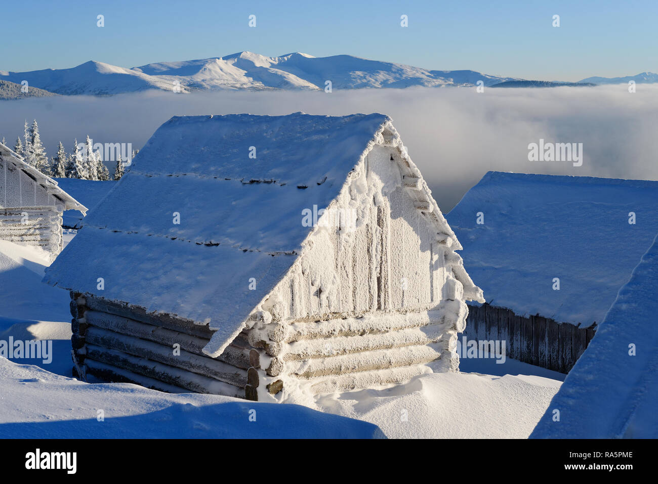 Winter landscape with a mountain hut. Wooden house covered with frost on a frosty winter morning Stock Photo