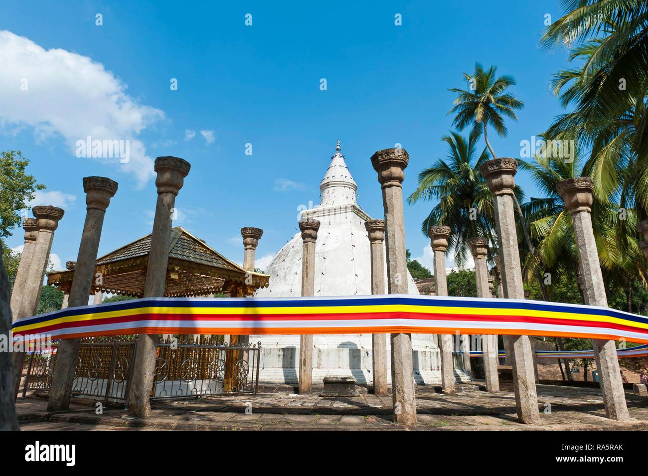White Stupa, single pillars, watadage, colorful ribbon in the colors of Buddhism, Temple Ambasthale-Dagoba, Mihinthale Stock Photo