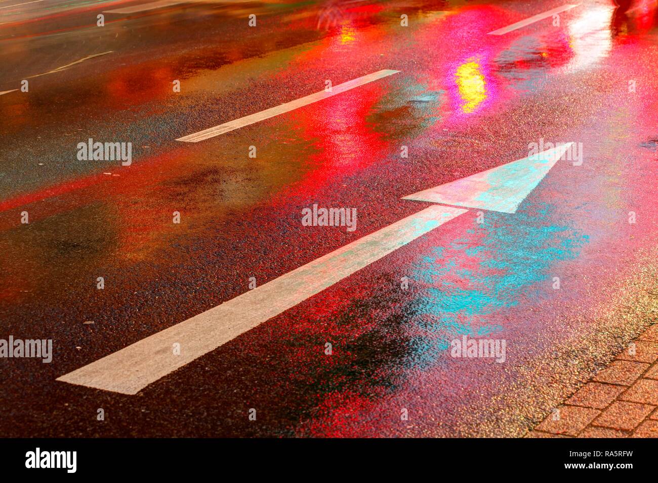 Wet street, lights, direction arrow in rain at dusk, Bremen, Germany Stock Photo