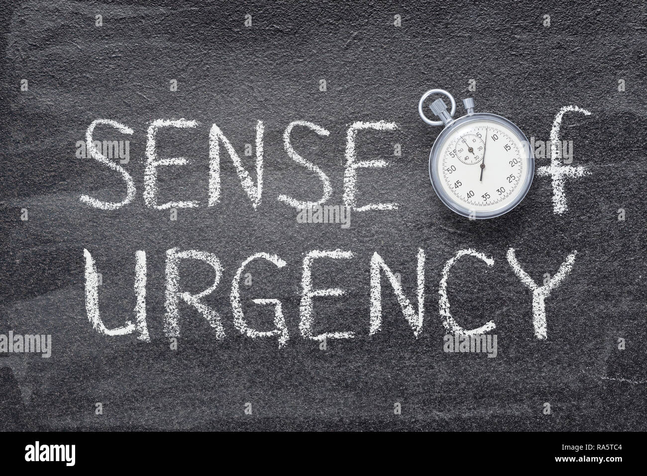sense of urgency phrase handwritten on chalkboard with vintage precise stopwatch used instead of O Stock Photo