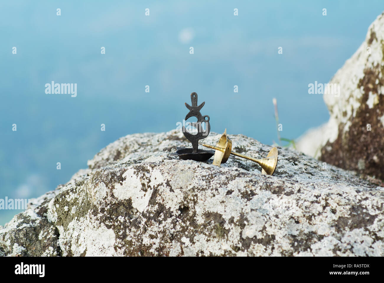 Om symbol and an oil lamp on a rock Stock Photo