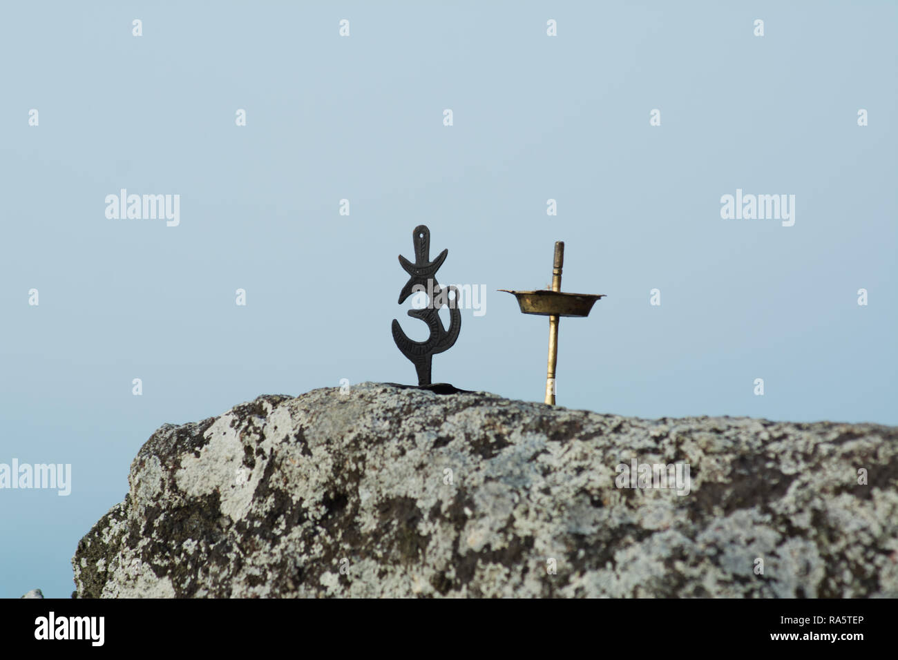 Om symbol and an oil lamp on a rock Stock Photo