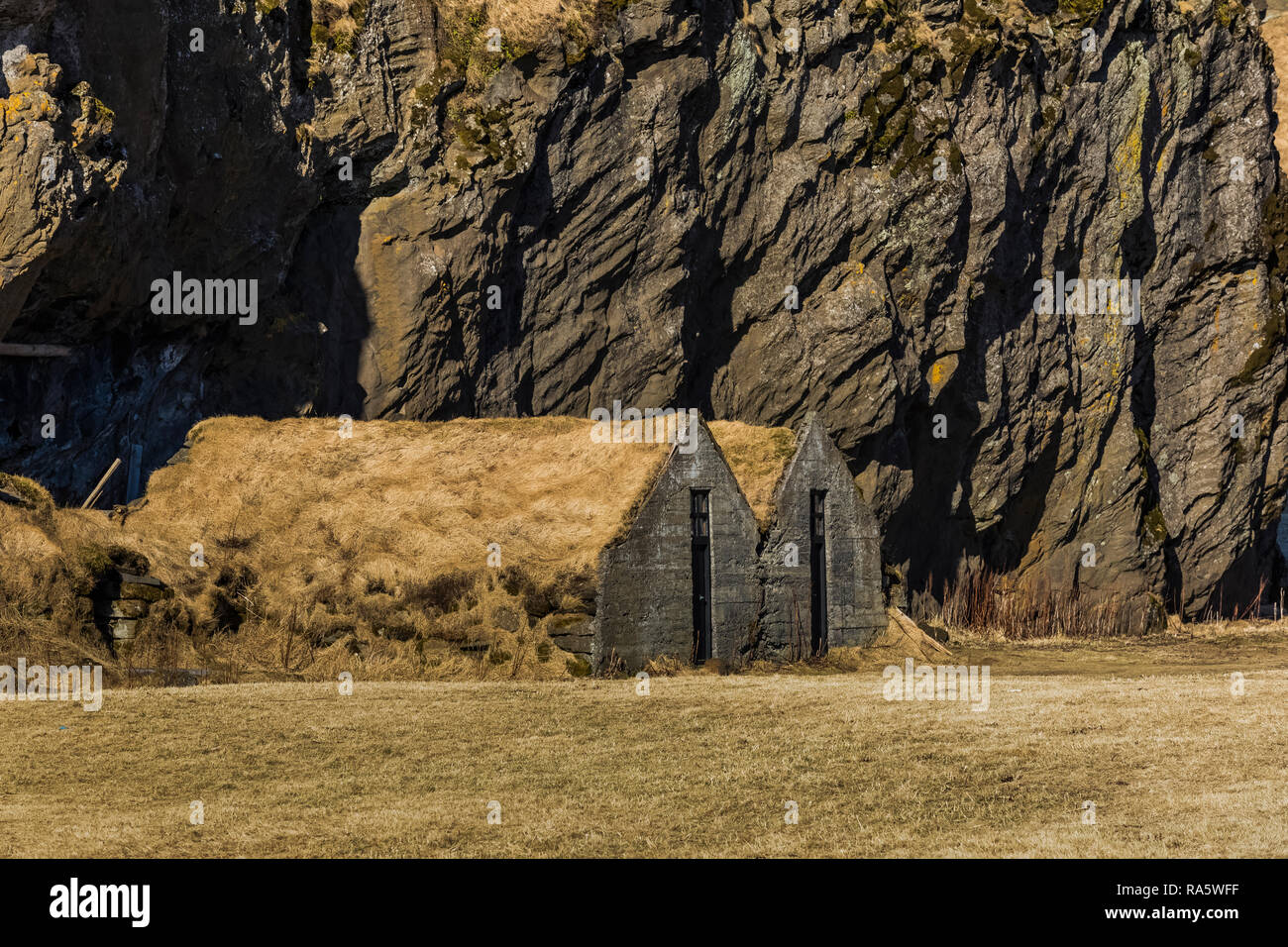 Concrete barns with sod roofs at Drangshlíð 2, at Drangurinn Rock, said to be home to elves, Iceland Stock Photo