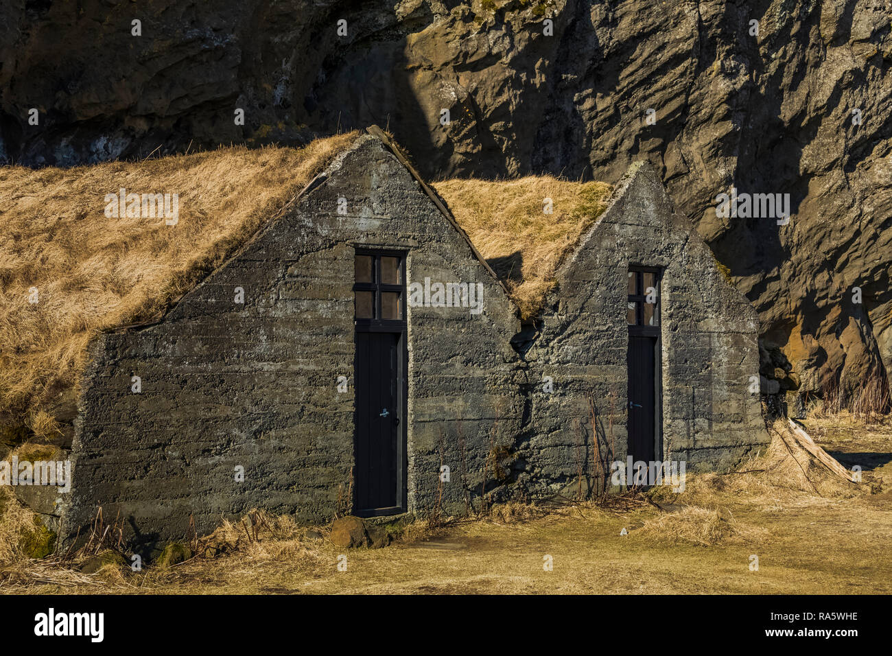 Concrete barns with sod roofs at Drangshlíð 2, at Drangurinn Rock, said to be home to elves, Iceland Stock Photo