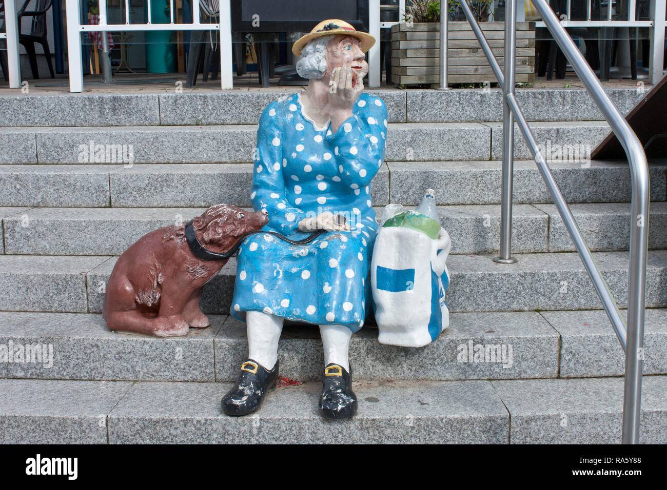 Elderly woman with a dog, sculpture on stairs, Heringsdorf, Usedom Island, Mecklenburg-Western Pomerania Stock Photo
