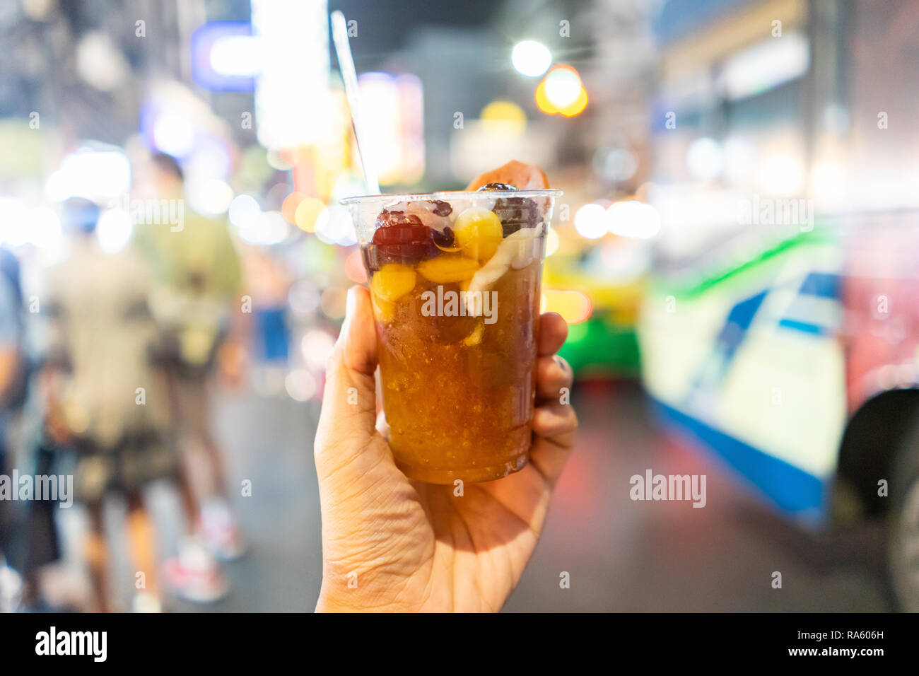 Modern chinese dessert on hand holding with copy space at China town blurry background, Bangkok Thailand. Stock Photo