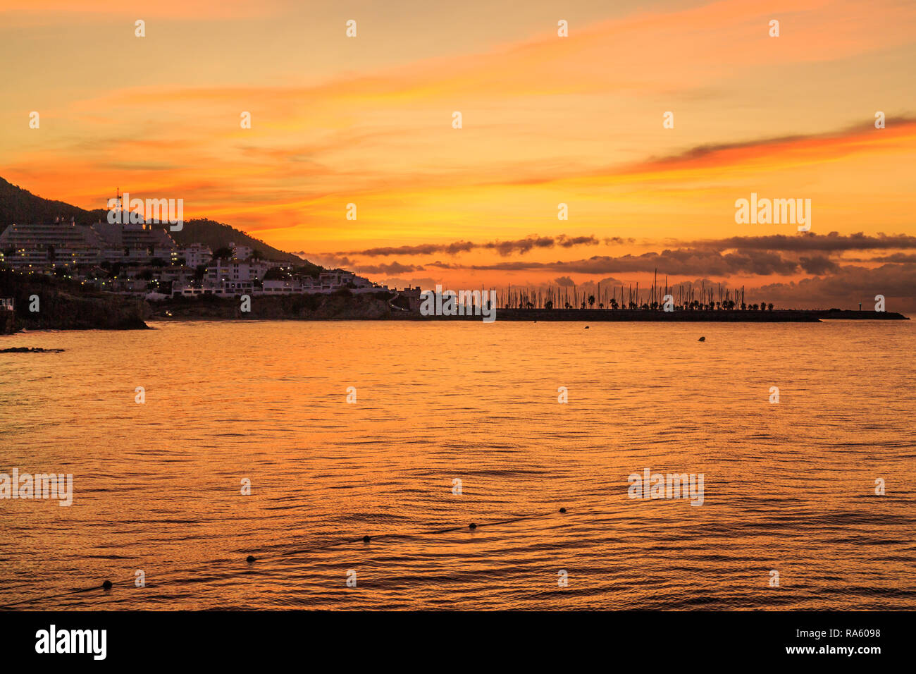 Orange dawn and sunrise over Sitges port, Spain Stock Photo