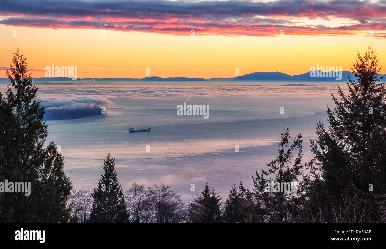 Burrard Inlet Sunset. Scenic view of this British Columbia waterway and the Strait of Georgia from West Vancouver. Seascape background with copy space. Stock Photo
