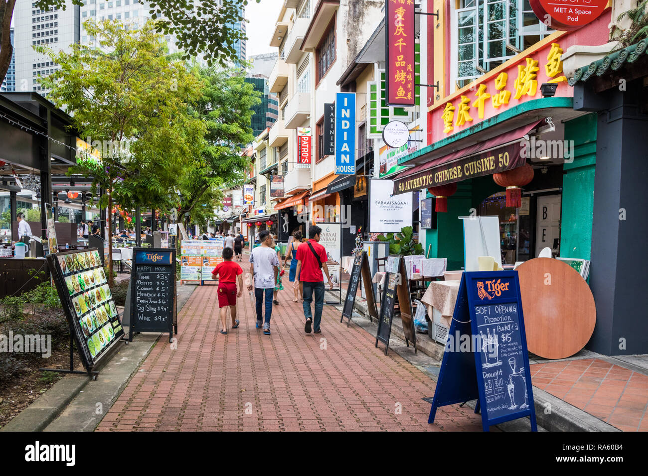 Singapore - 14th December 2018: People walking past restaurants and bars on Boat Quay. The street is popular with both tourists and expats. Stock Photo