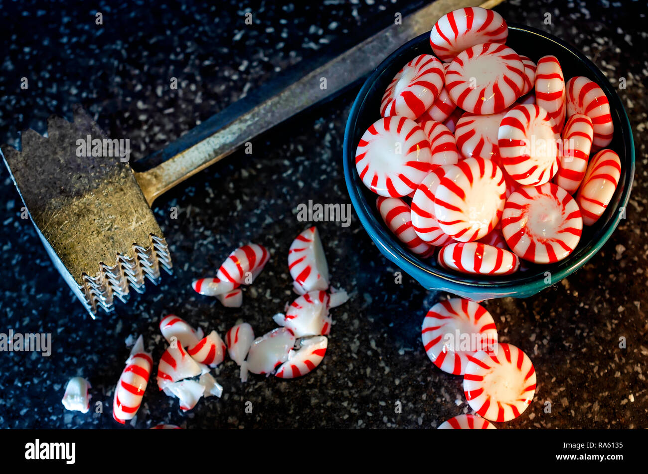 Peppermint candy is crushed with a vintage meat tenderizer mallet in preparation to make peppermint bark, Dec. 31, 2018, in Coden, Alabama. Stock Photo