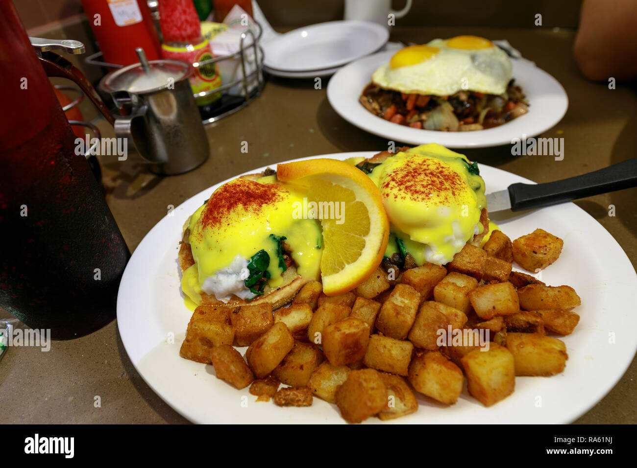 Eggs Benedict - Traditional American breakfast with potato salad Stock Photo