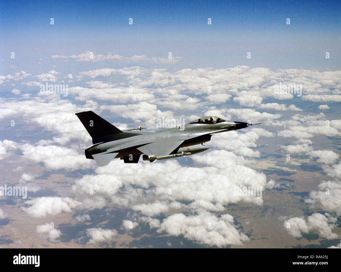 1977 - An air to air right side view of a YF-16 Fighting Falcon aircraft armed with AIM-9 Sidewinder missiles on the wing tips. Stock Photo