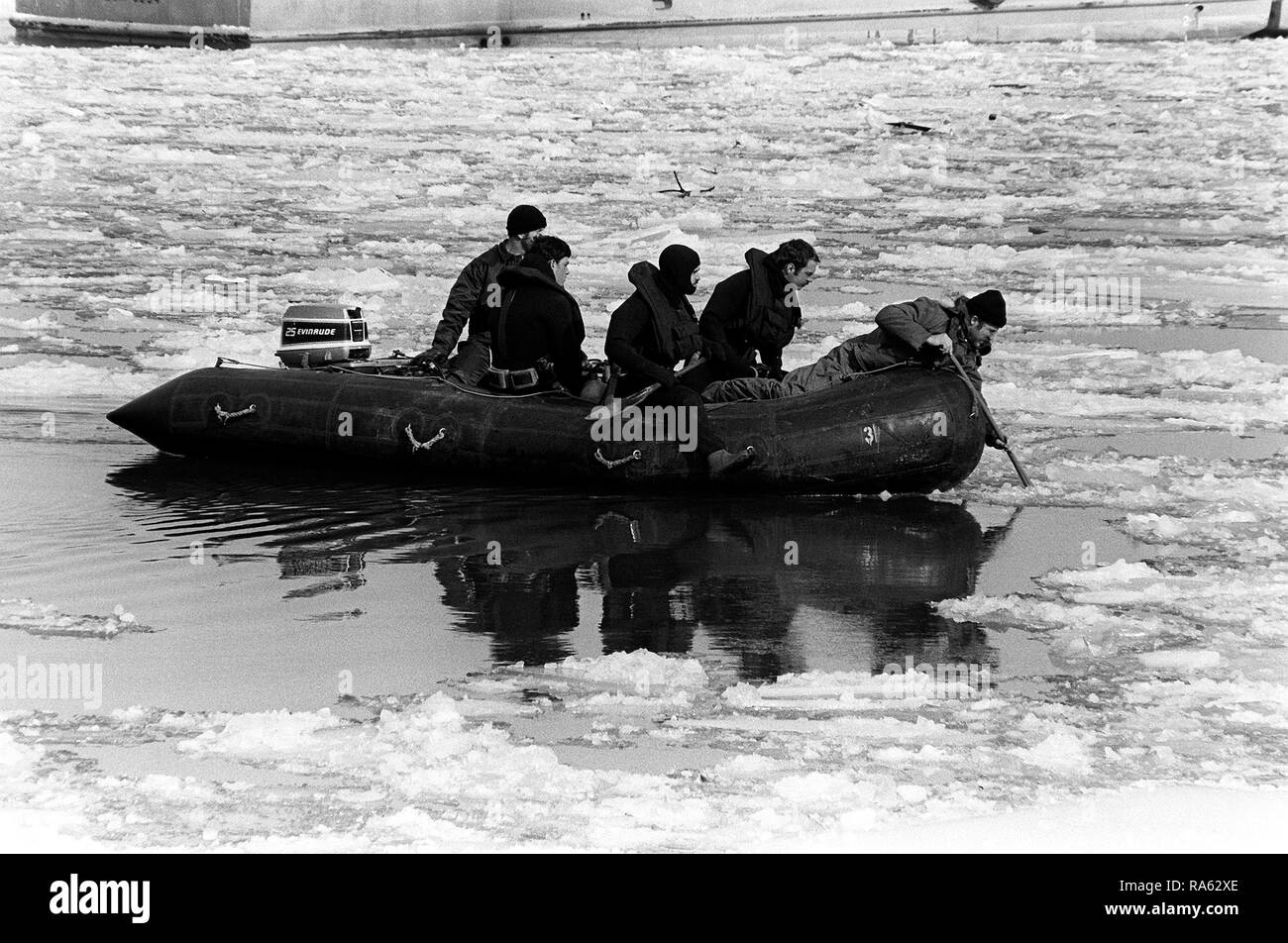 1982 - A Navy dive team navigates a rubber raft through the icy water searching for victims and wreckage from Flight 90, the Air Florida Boeing 737 that crashed into Rochambeau Bridge (14th Street). Stock Photo
