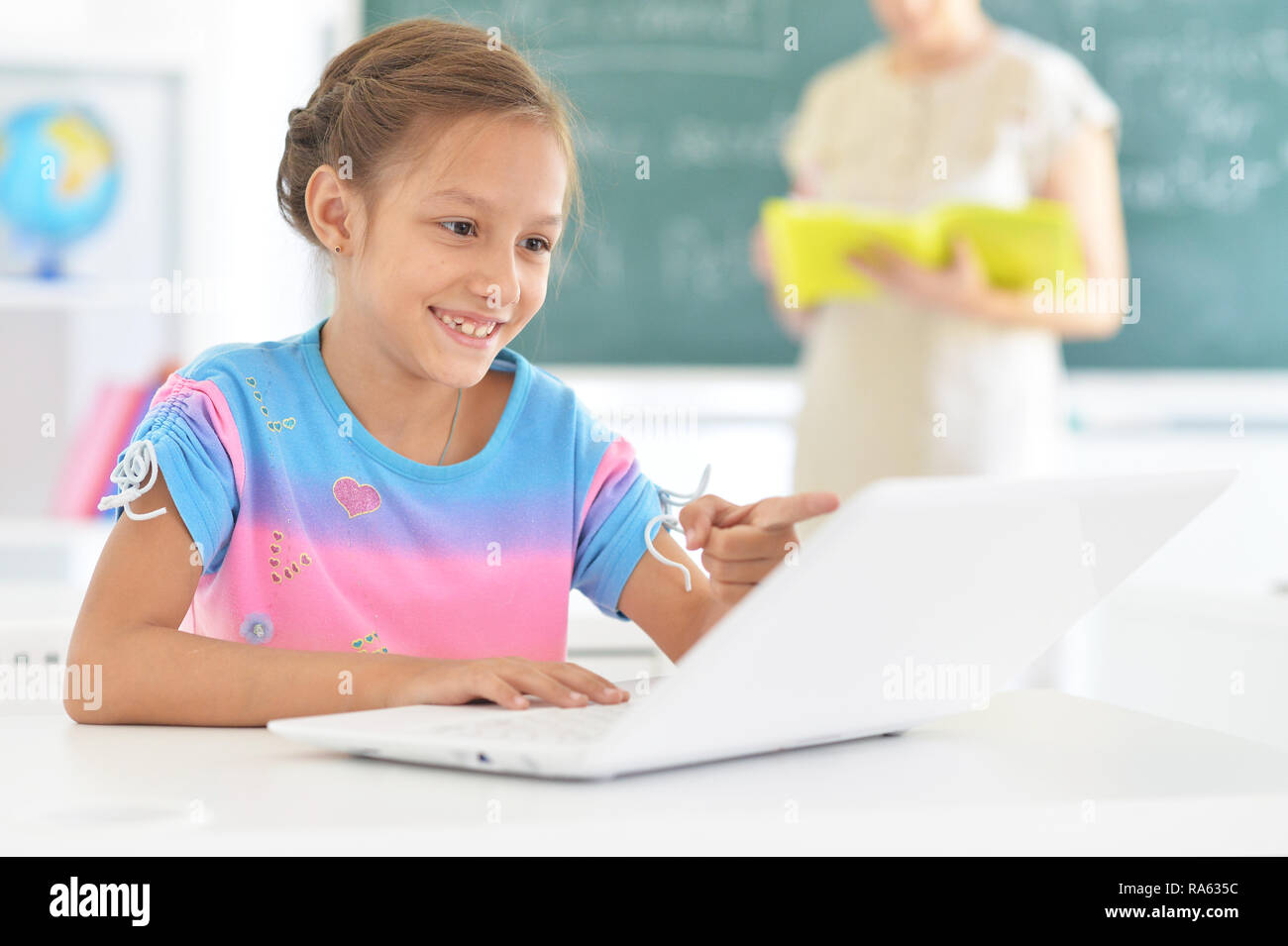 Portrait of emotional little girl using laptop Stock Photo - Alamy