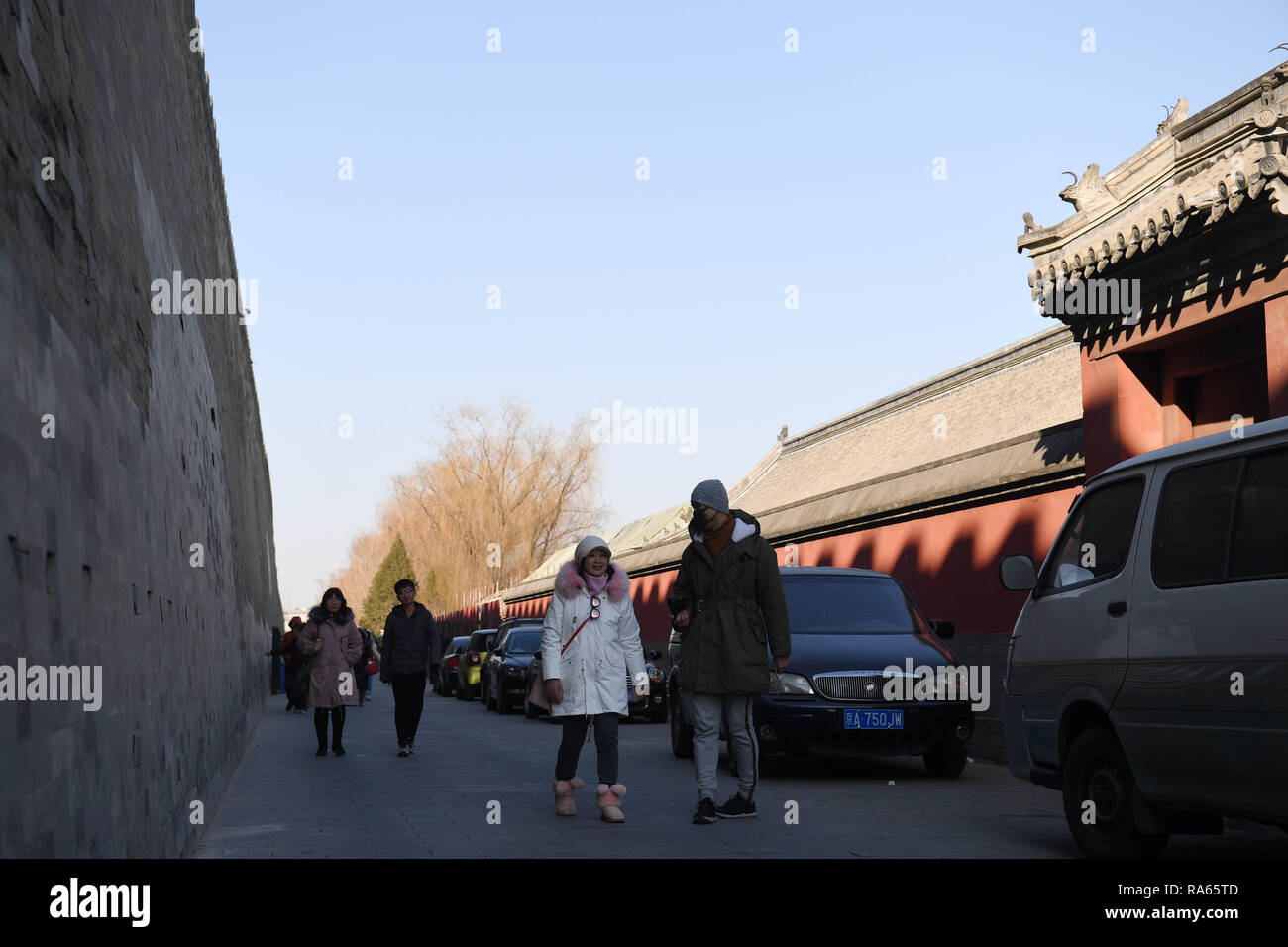 (190101) -- BEIJING, Jan. 1, 2019 (Xinhua) -- Tourists walk past the wall of the Palace Museum in Beijing, capital of China, Jan. 1, 2019. In order to further enhance visiting experiences and loosen pressure on exits, starting from Jan. 1, 2019, the museum will open the area between its northern Gate of Divine Prowess (Shenwu) and eastern Gate of East Glory (Donghua). (Xinhua/Jin Liangkuai) Stock Photo