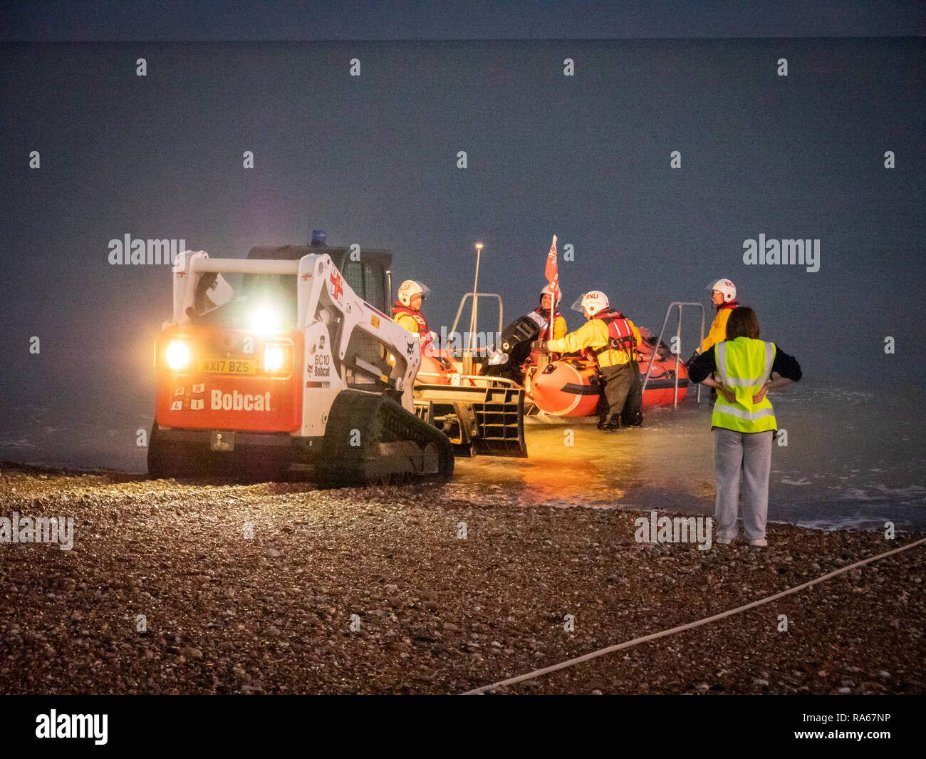 Eastbourne, East Sussex, UK, 1st January 2019. The RNLI Lifeboat is launched from the beach on the south coast just as it gets dark at the South Coast seaside resort. The crew pushed the D class inshore lifeboat down the shingle beach with a small tractor and sped off into the darkness. Credit: Julian Eales/Alamy Live News Stock Photo