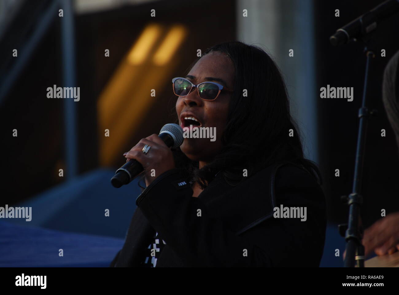 Oakland, California, USA. 1st Jan, 2019. Oscar Grant's mother, Wanda Johnson, sings at a vigil outside the Fruitvale BART station in Oakland, California, marking the tenth anniversary since he was shot and killed by a police officer. Credit: Scott Morris/Alamy Live News Stock Photo