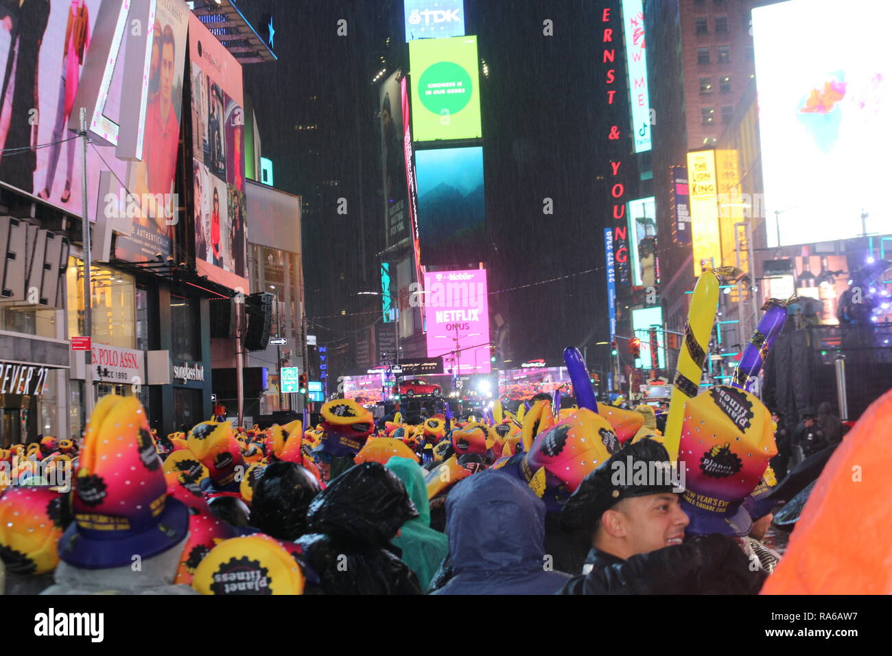 People are seen gathered at the Times Square during the New Year's Eve celebrations. Despite all day rain, More than 2 million people participate at the New Year's Eve celebrations at the Times Square. Stock Photo