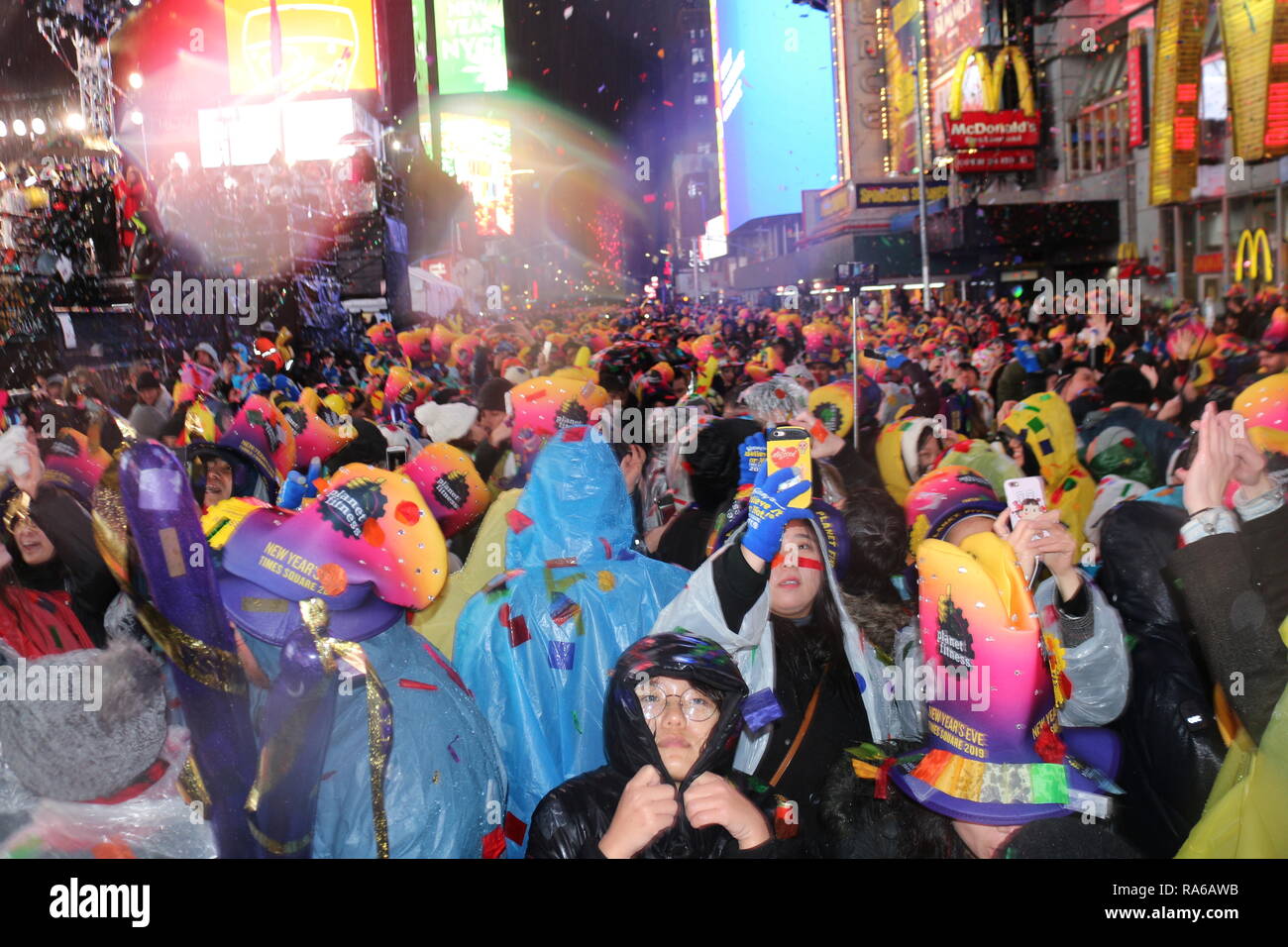 People are seen gathered at the Times Square during the New Year's Eve celebrations. Despite all day rain, More than 2 million people participate at the New Year's Eve celebrations at the Times Square. Stock Photo