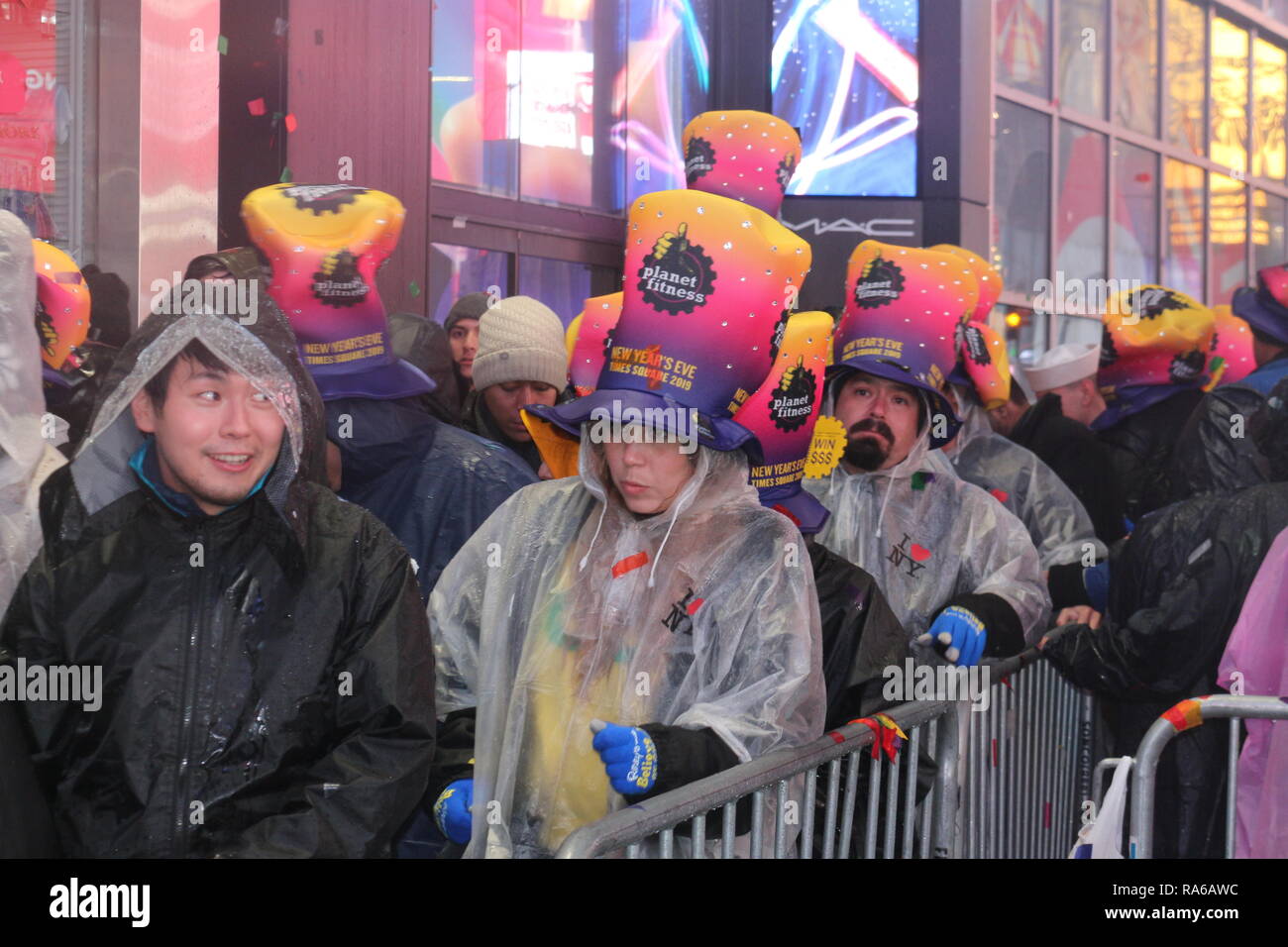 Participants are seen at the Times Square during the New Year's Eve celebrations. Despite all day rain, More than 2 million people participate at the New Year's Eve celebrations at the Times Square. Stock Photo