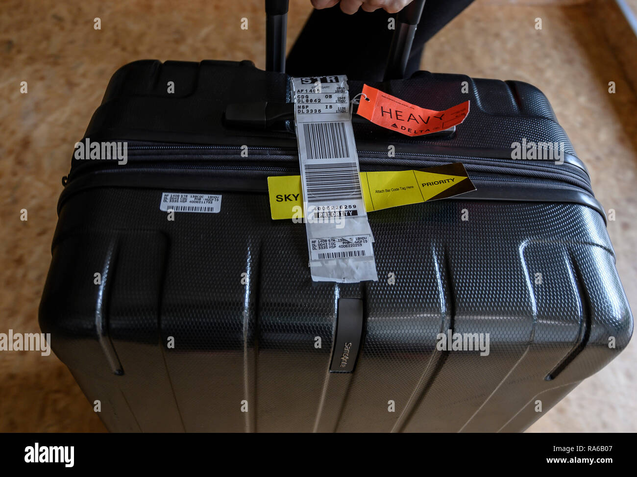 25 December 2018, Baden-Wuerttemberg, Göppingen: A conventional luggage band with a bar code and the final destination Stuttgart (STR) is attached to a roll case. Airlines want to significantly reduce the loss of suitcases and in future provide each piece of luggage with an RFID chip that can be read via radio waves. (to dpa 'Well landed, suitcase gone - with RFID chip against loss of flight luggage' from 02.01.2019) Photo: Daniel Maurer/dpa Stock Photo