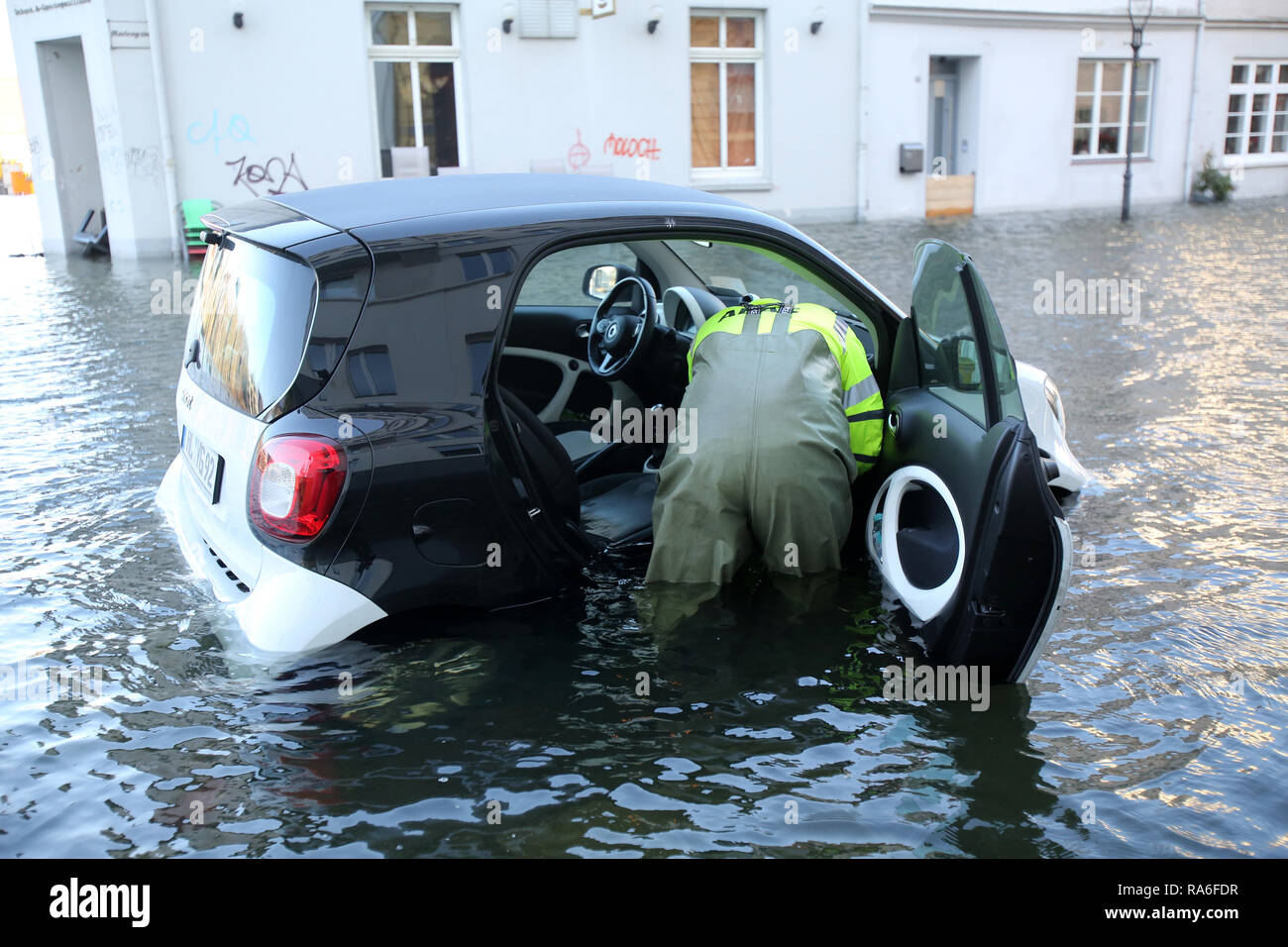 Schleswig-Holstein, Lübeck. 02 January 2019, A vehicle is pulled out of the water of the Trave river during a storm tide in the street Marlesgrube. Photo: Bodo Marks/dpa/Alamy Live News Stock Photo