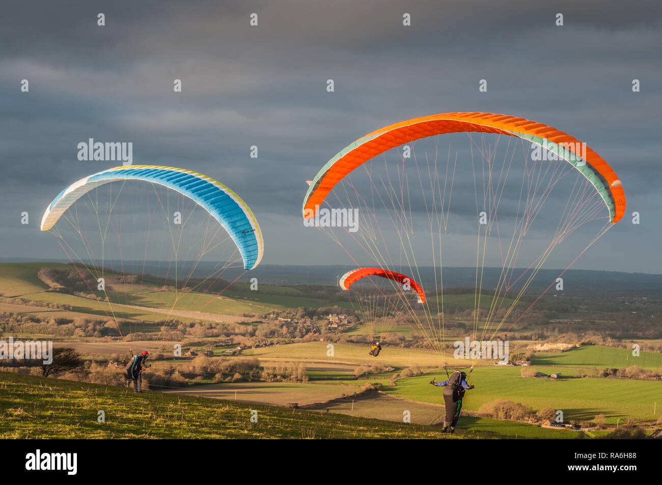 Firle, Lewes, East Sussex, UK. 2nd January 2019. Northerly wind brings paraglider pilots to Firle Beacon in the beautiful South Downs. Varying conditions throughout the day, flying continued to sunset.Credit: Alamy Live News Stock Photo
