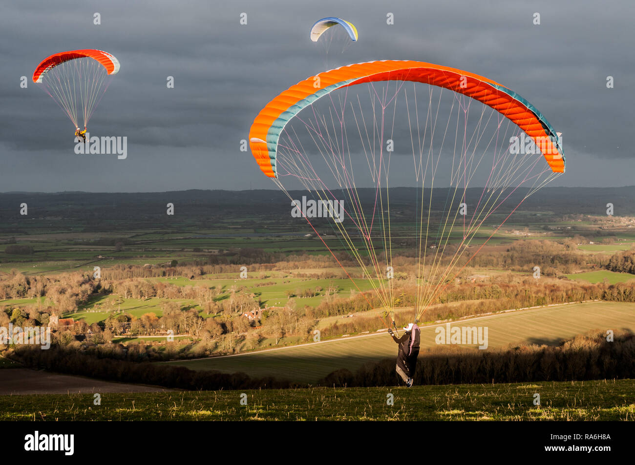 Firle, Lewes, East Sussex, UK. 2nd January 2019. Northerly wind brings paraglider pilots to Firle Beacon in the beautiful South Downs. Varying conditions throughout the day, flying continued to sunset.Credit: Alamy Live News Stock Photo