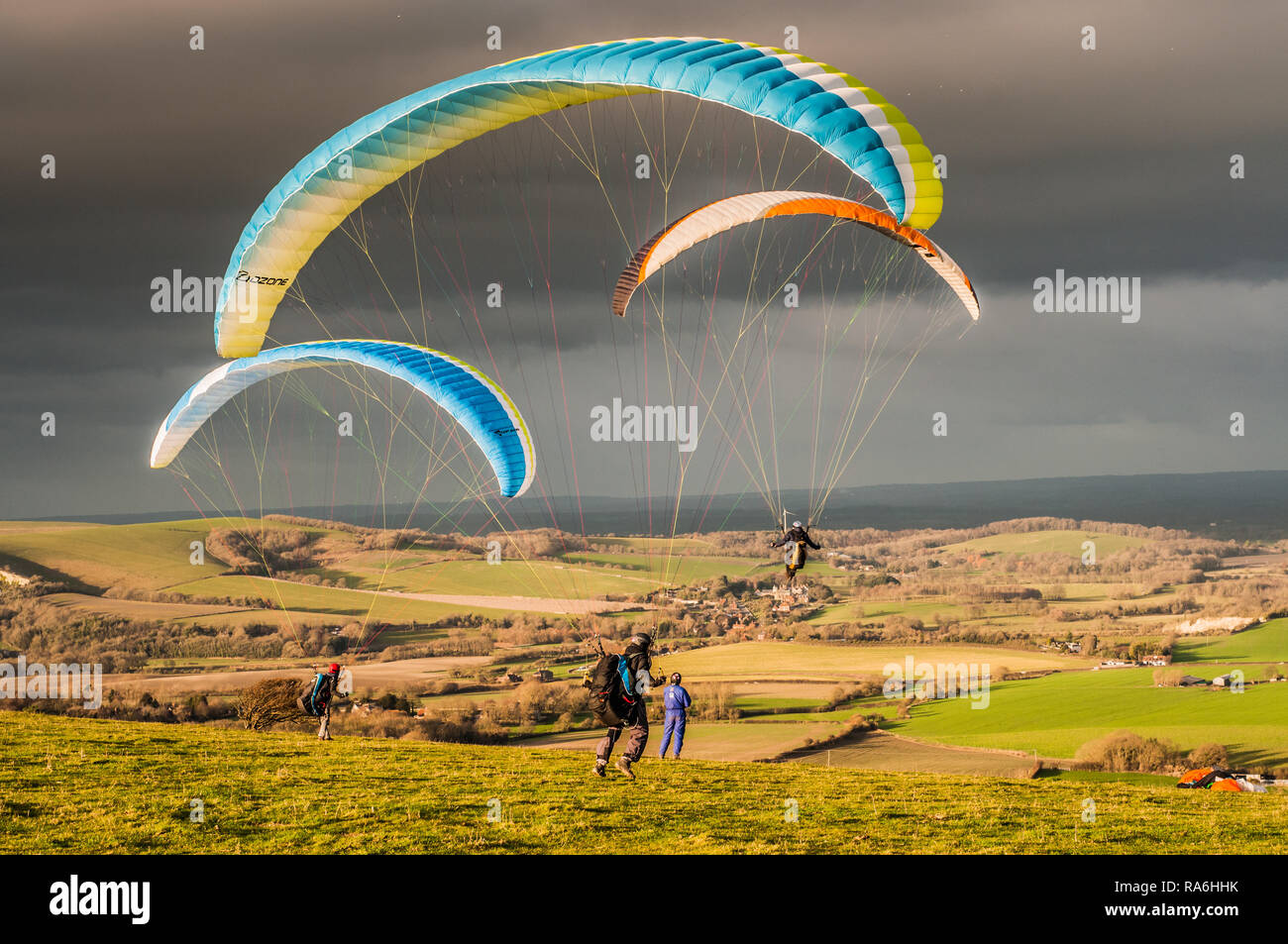 Firle, Lewes, East Sussex, UK. 2nd January 2019. Northerly wind brings paraglider pilots to Firle Beacon in the beautiful South Downs. Varying conditions throughout the day, flying continued to sunset. Stock Photo