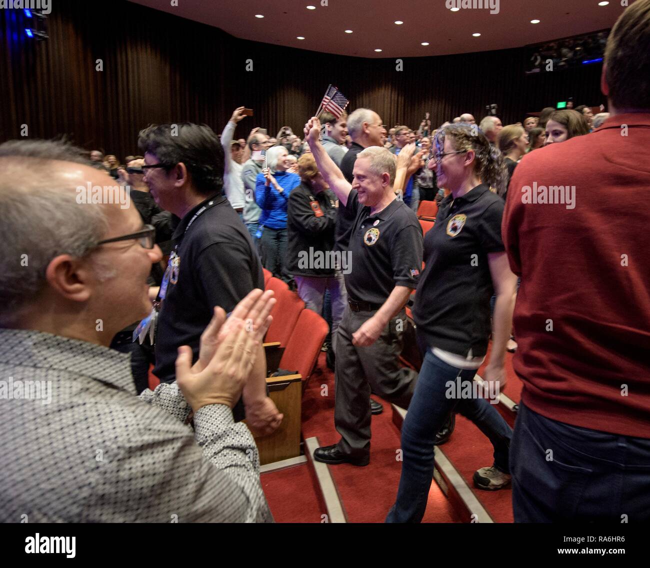 New Horizons principal investigator Alan Stern, center, of the Southwest Research Institute, along with other mission team members, wave American flags as they arrive for a press conference following the successful flyby of Ultima Thule at Johns Hopkins University Applied Physics Laboratory January 1, 2019 in Laurel, Maryland. Stock Photo