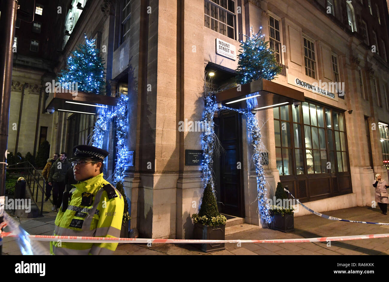 Police outside the Grosvenor House Suites in Park Lane, London after a security guard was stabbed to death and three others injured as they tried to bar a group of men from entering a New Year's Eve party. Stock Photo
