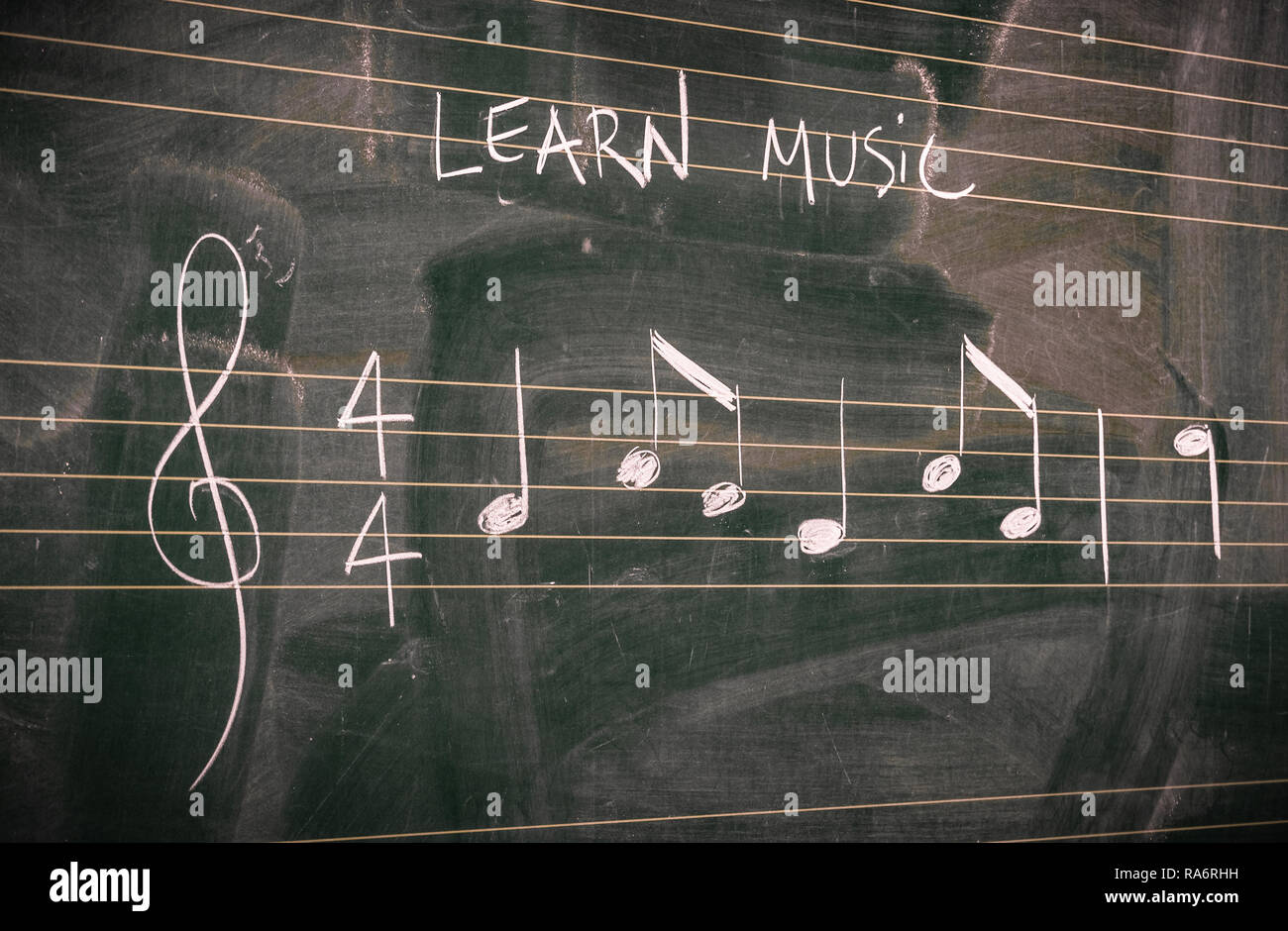 Random music notes written with white chalk on a blackboard. Learn or teach music concepts. Stock Photo