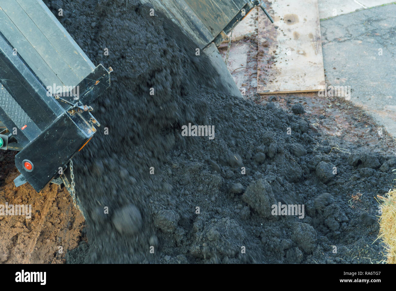 Earthworks with truck dumping and tipping raw earth soil. Tip truck