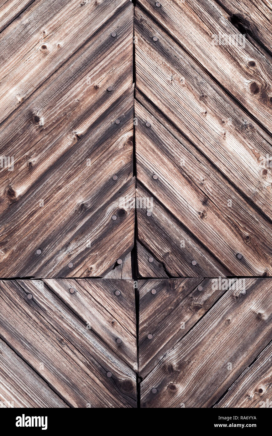 Closeup detail of decorative rustic woodwork and nails with natural weathered dark vintage wood on a rural farm facade - Wooden antique background Stock Photo