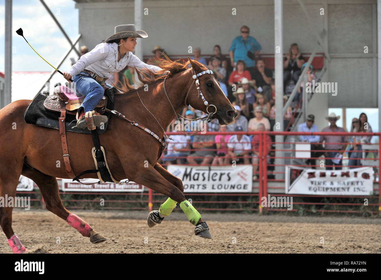 A barrel racing contestent riding her horse fast to the finish line at