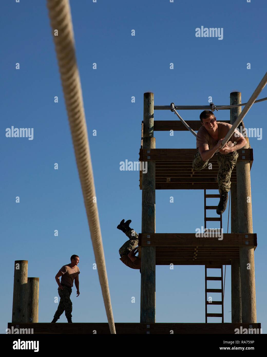 U.S. Navy SEAL candidates cross a rope bridge during Basic Underwater Demolition SEAL training at the Navy Special Warfare Center April 9, 2018 in Coronado, California. SEALs are the maritime component of U.S. Special Forces and are trained to conduct a variety of operations from the sea, air and land. Stock Photo