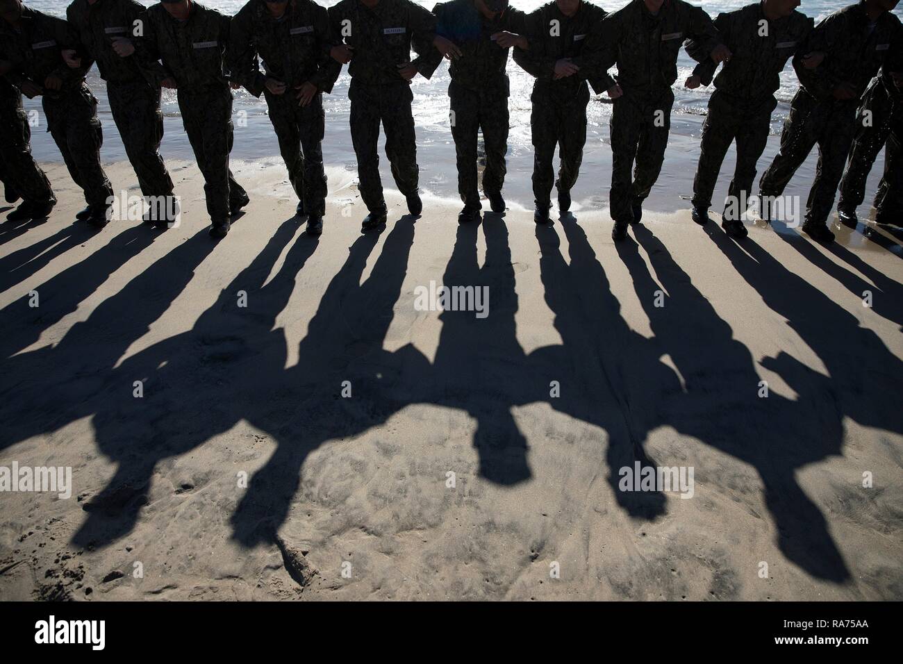 U.S. Navy SEAL candidates back into the surf during Basic Underwater Demolition SEAL training at the Navy Special Warfare Center April 9, 2018 in Coronado, California. SEALs are the maritime component of U.S. Special Forces and are trained to conduct a variety of operations from the sea, air and land. Stock Photo