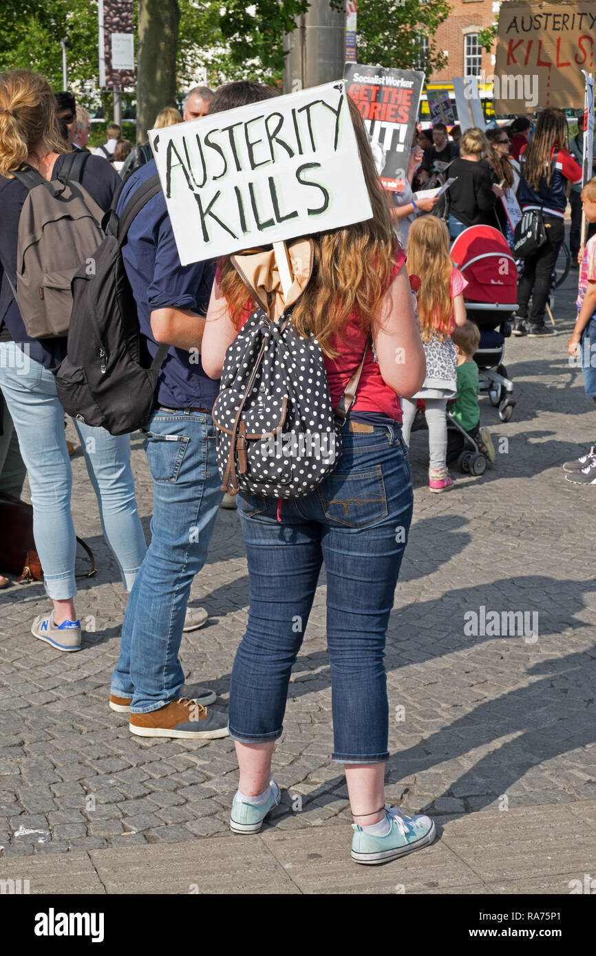 An anti-austerity demonstrator holds a placard with the slogan “AUSTERITY KILLS” in Bristol, UK on 8 July 2015. Stock Photo
