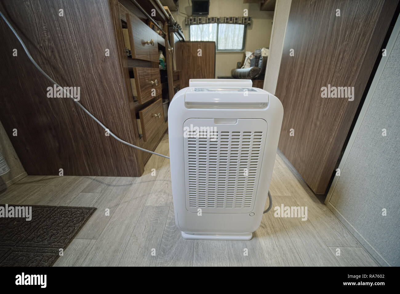 Desiccant dehumidifier inside RV travel trailer with drawers and cabinets open. Done to keep RV dry while in storage. Stock Photo