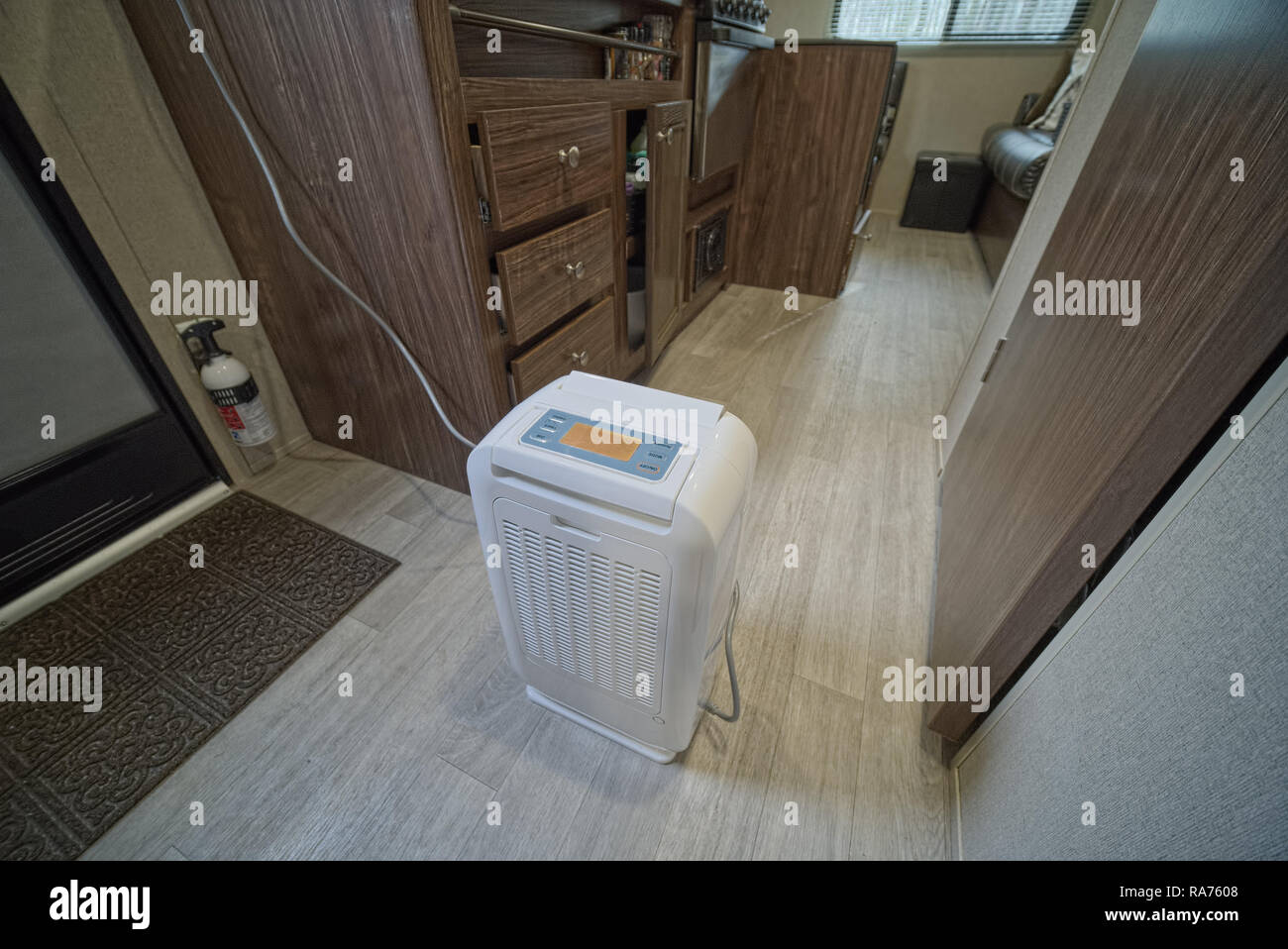 Desiccant dehumidifier inside RV travel trailer with drawers and cabinets open. Done to keep RV dry while in storage. Stock Photo