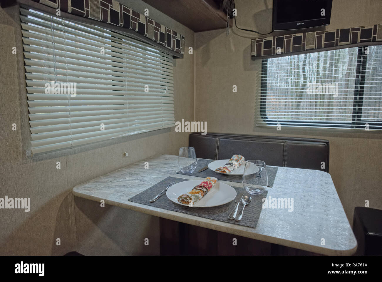 Set table inside RV travel trailer. Dining table in RV camper Stock